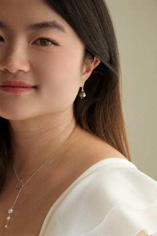 Model wearing Kizuna pearl lariat necklace styled as choker and dangle, 18-inch length