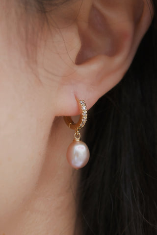 odel wearing Megumi purple pearl huggie earrings, 1 inch length, statement everyday style